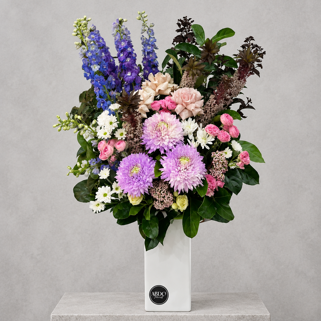 Purple-toned flower arrangement in a tall ceramic vase, by Abdo Florist Sydney