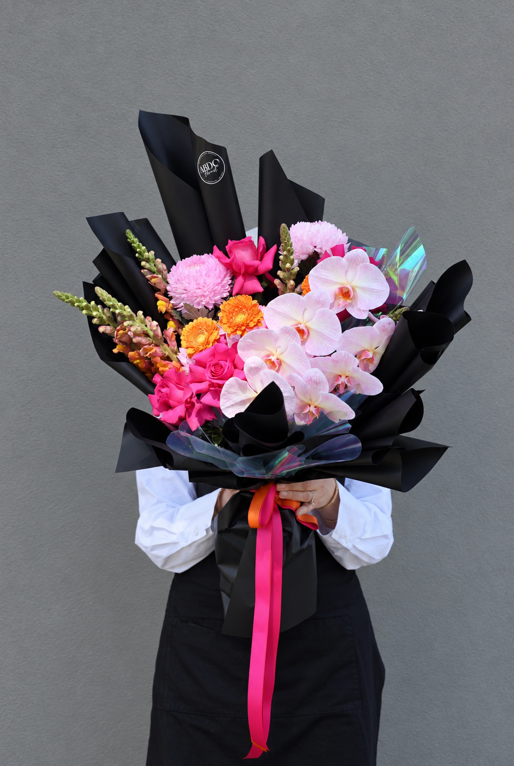 Pink rose and orchid bouquet in black wrap, by Abdo Florist Sydney